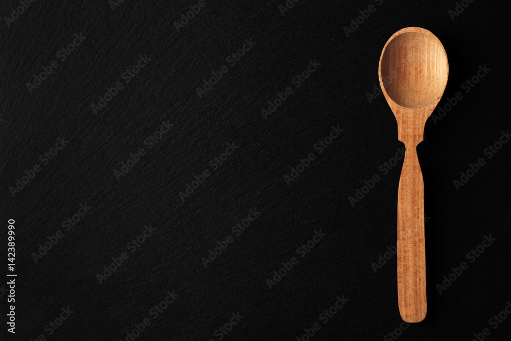 Wooden spoon on the black stone background Wooden spoon on the black stone background