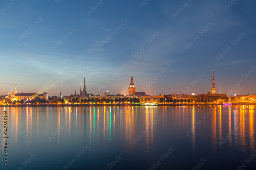 Old Riga night skyline. Illuminated city after sunset. Panoramic view over Daugava river