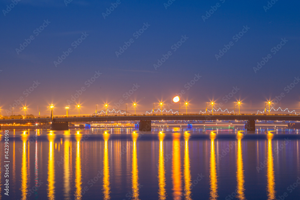 Daugava river and the railway bridge. Night panoramic scene in Riga, Latvia