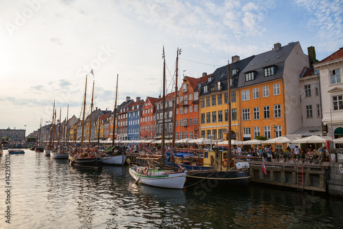 COPENHAGEN, DENMARK - 26 JUNE, 2016: People are relaxing in small canal with colorful houses and boats