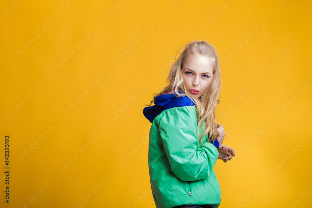 portrait of beautiful blond woman in sunglasses and blue green jacket on yellow background. hipster summer. portrait of beautiful blond woman in sunglasses and blue green jacket on yellow background. hipster summer.