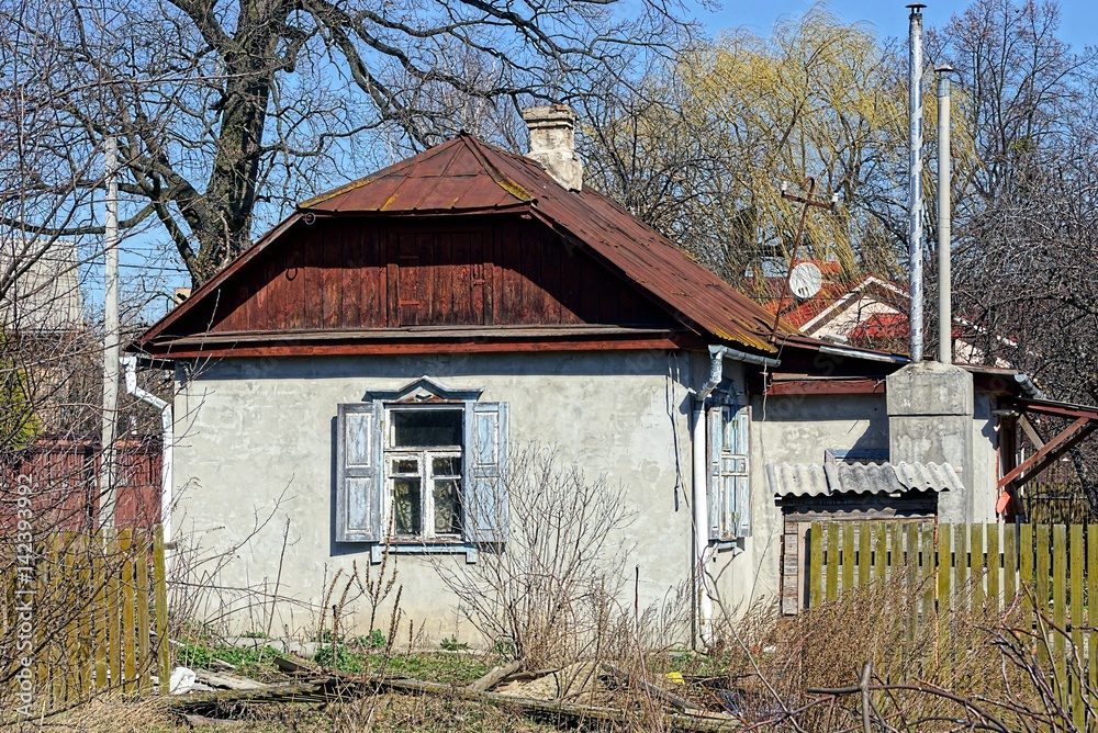 Fototapeta premium Сельский домик с белой стеной и деревянными ставнями