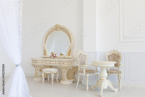 White dressing table and chair in a living room. Modern classics with rococo elements