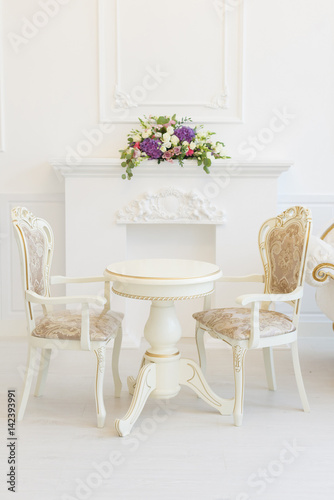 Bright luxury white interior living room with flowers . the walls are decorated with baroque ornaments © monoliza