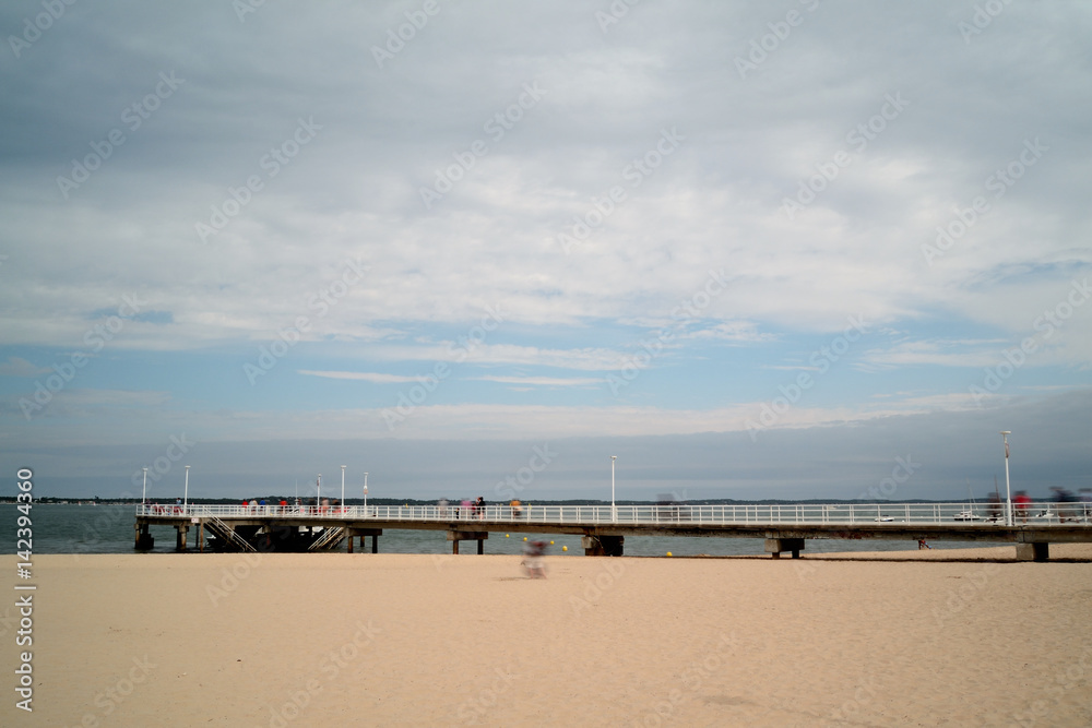 seaside landscape. Beach and pier, cloudy day