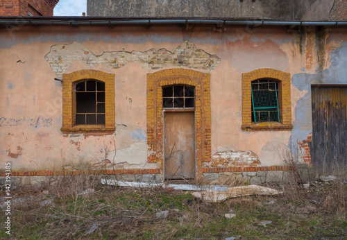 Old, destroyed building with door and two windows. © martakobiela