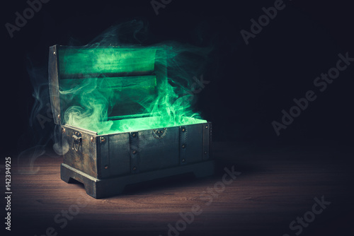 open pandora's box with green smoke on a wooden background /high contrast image