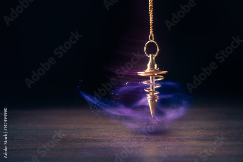 Pendulum used for readings and hypnotism swinging with motion blur