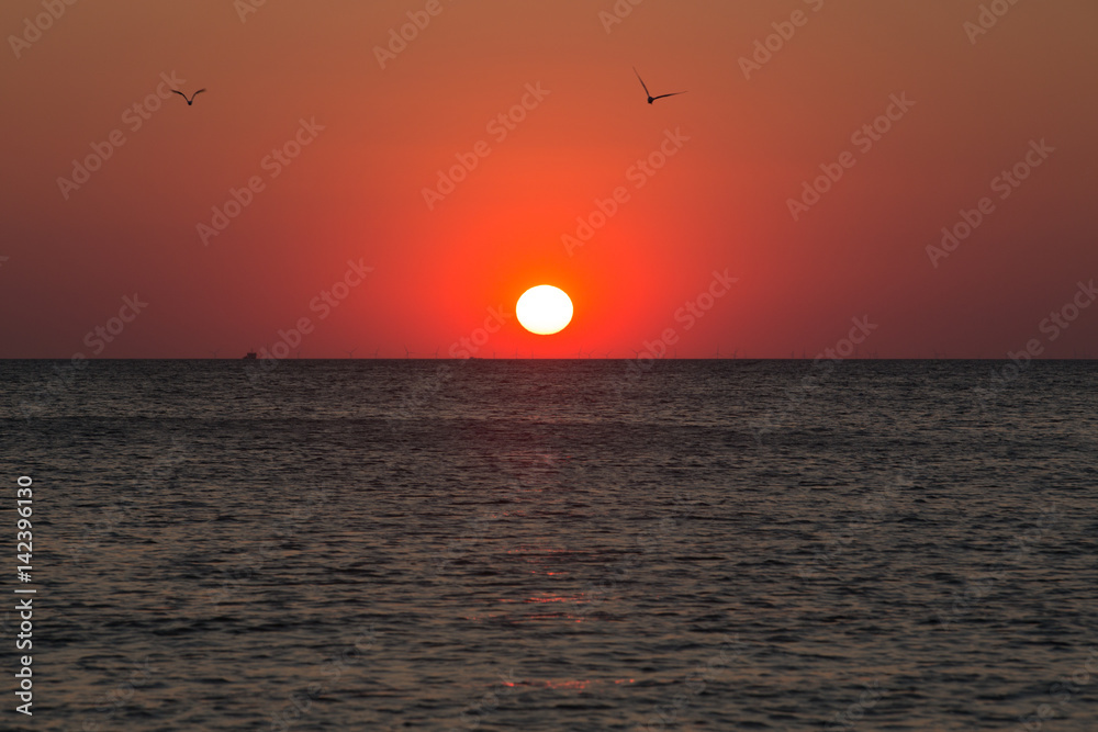 Rote Sonne über dem Meer