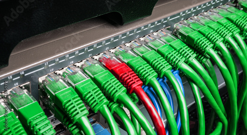 Server rack with green and red internet patch cord cables