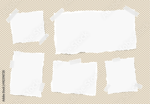 Different size white note, notebook, copybook sheets, strips stuck with sticky tape on squared brown background