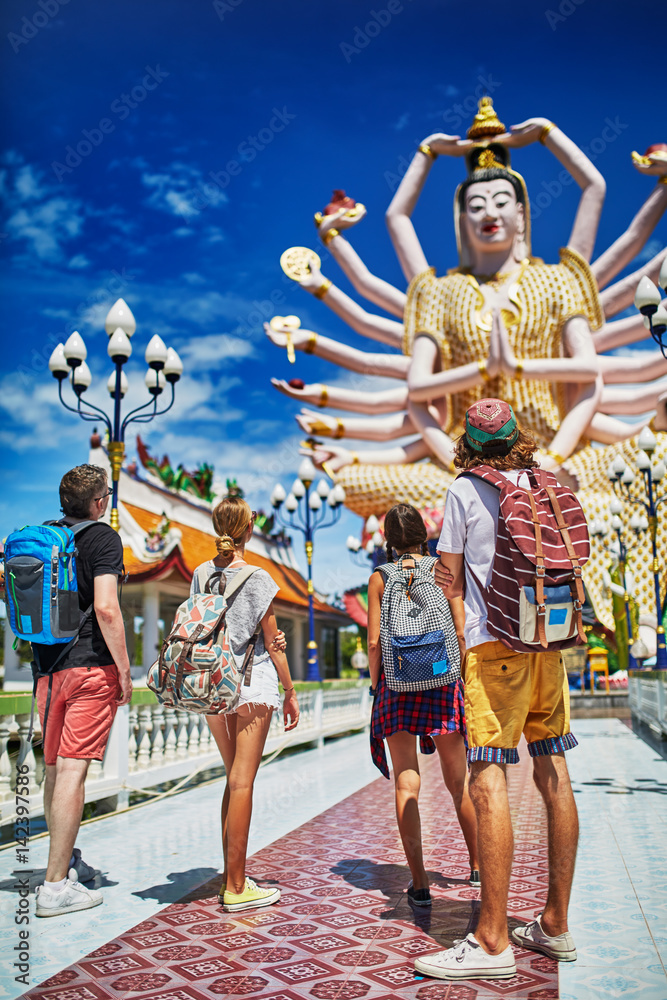 Fototapeta premium group of tourists looking at buddhist temple in thailand