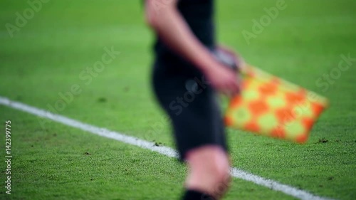 Assistant referee moving along the sideline during a soccer match photo