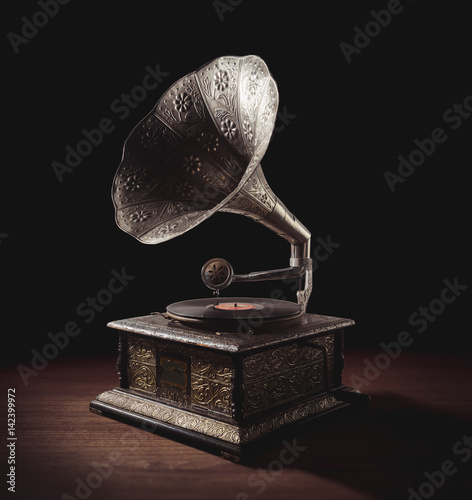 Old Gramophone with dramatic lighting on a wooden background