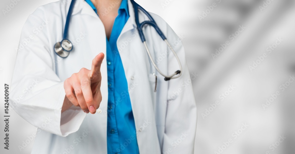 Doctor mid section pointing against blurry background Doctor mid section pointing against blurry background