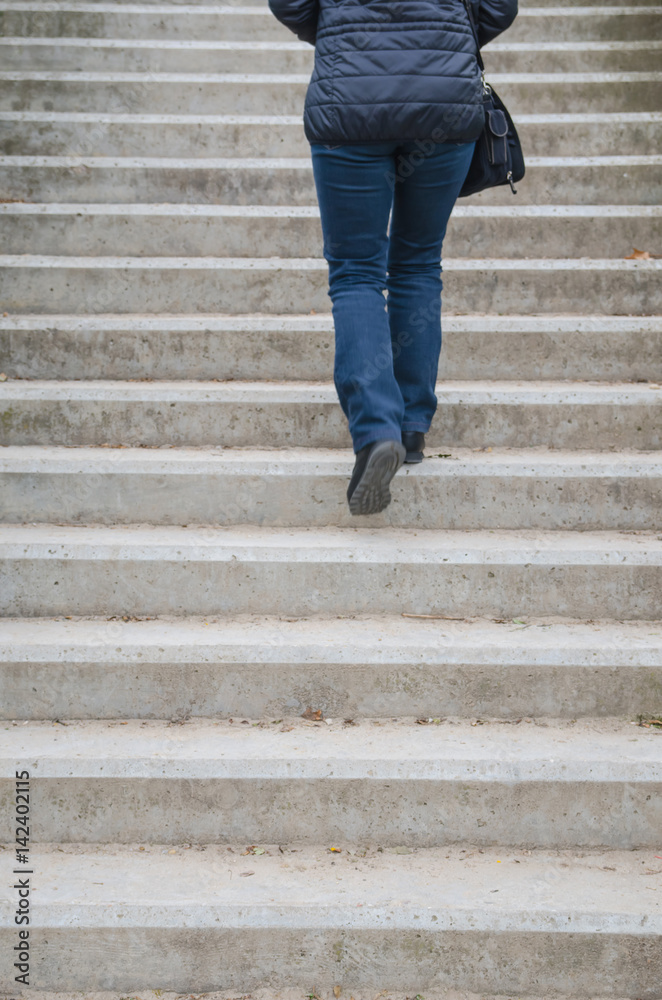 Woman going up on dirty concrete stairs