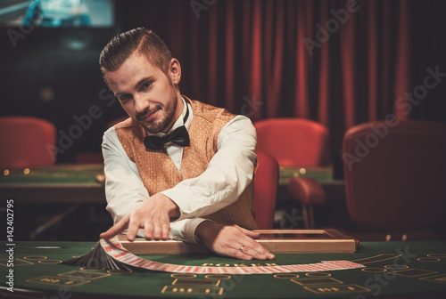 Croupier behind gambling table in a casino