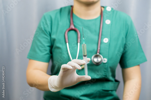 Doctor holding syringe and getting ready for injection,female doctor holding syringe with injection,Nurse or female doctor holding an injection needle.vintage color,selective focus,medical concept