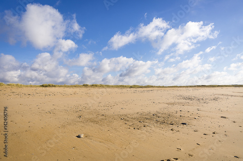 sandy beach in Vendee, France with blue sky and white clouds