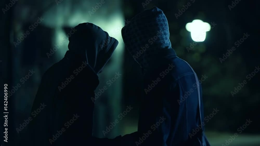 Two hooded men doing transaction at night,suspicious activity