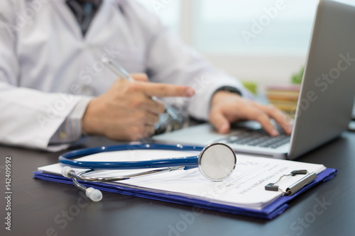 Stethoscope with clipboard and Laptop on desk. Stethoscope on a prescription,Doctor working a Medical Exam, Healthcare and medically concept,test results in background,vintage color,selective focus © Have a nice day 