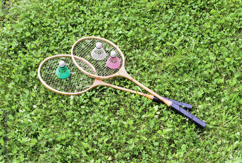Badminton rackets and shuttlecocks on grass