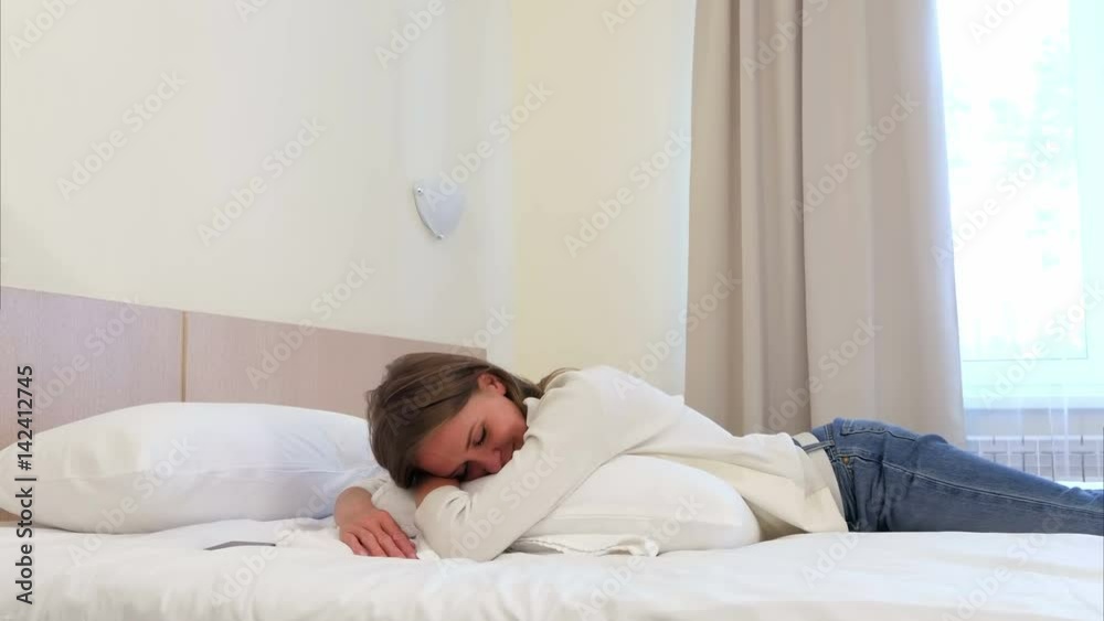 Relaxed pretty young woman sleeping on white bed in hotel room Relaxed pretty young woman sleeping on white bed in hotel room