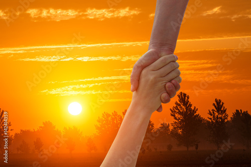 helping hand with the sky sunset background