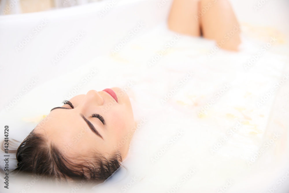 Naklejka premium Beautiful young woman taking bath at home