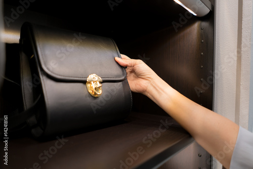 Foto The woman is watching a shoulder bag black from the display