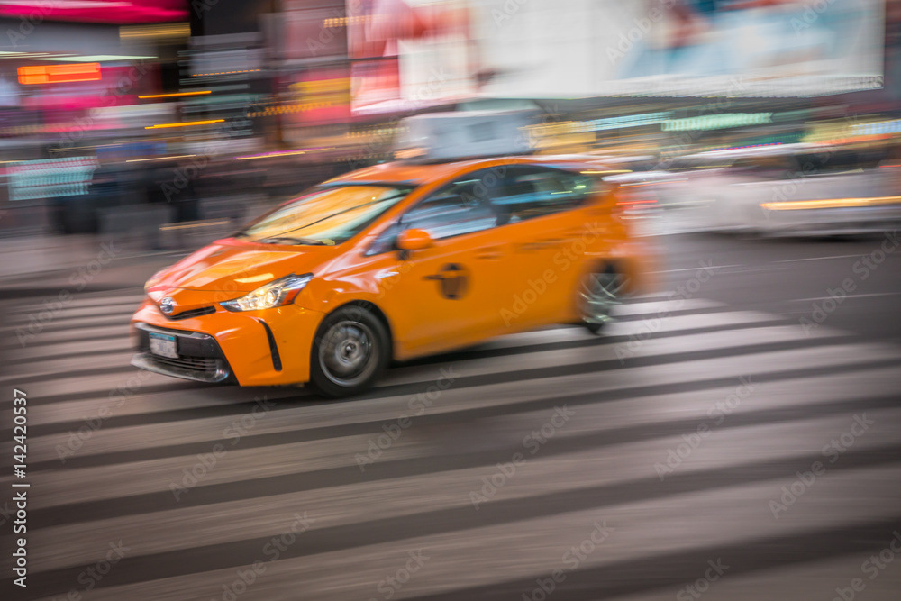 Taxi on city street at night moving fast