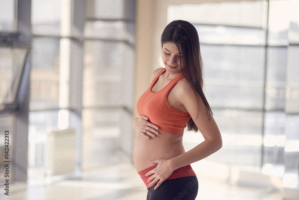 Young pregnant sportswomen