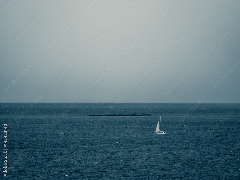 Sailboat on a sea in a cloudy day