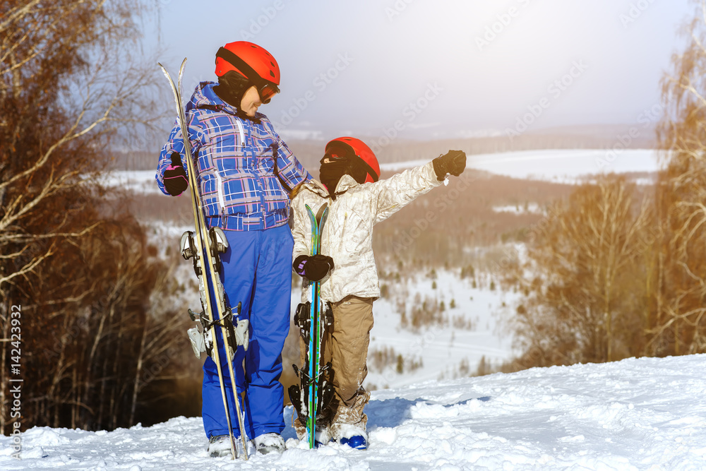 Mom and daughter, in ski equipment play with snow in