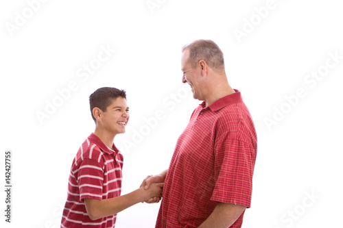 Happy Hispanic father and son shaking hands.
