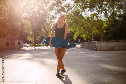 attractive young skater woman holding a skate