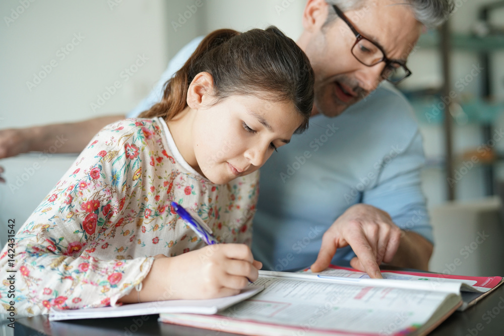Man helping daughter with homework Man helping daughter with homework