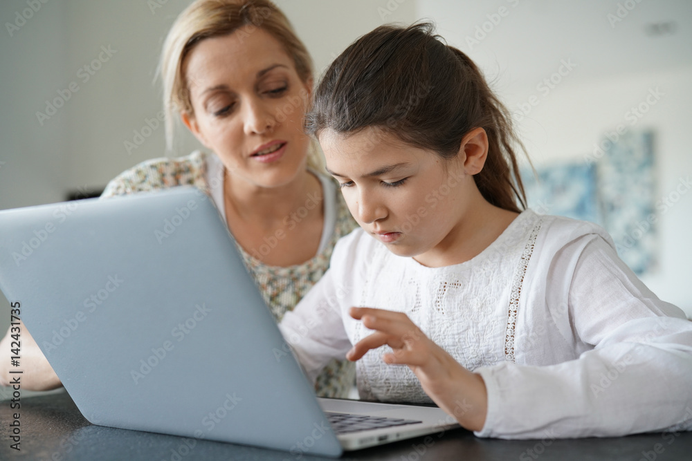 Woman watching her daughter while connected on internet Woman watching her daughter while connected on internet