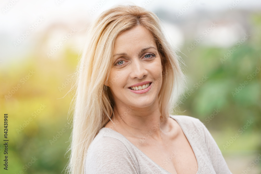 Naklejka premium Portrait of attractive blond woman standing outside