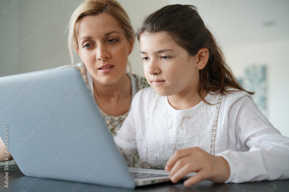 Woman watching her daughter while connected on internet Woman watching her daughter while connected on internet