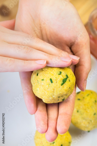 Making falafel balls. Female hands form round-shaped falafel pieces out of minced cheak peas photo