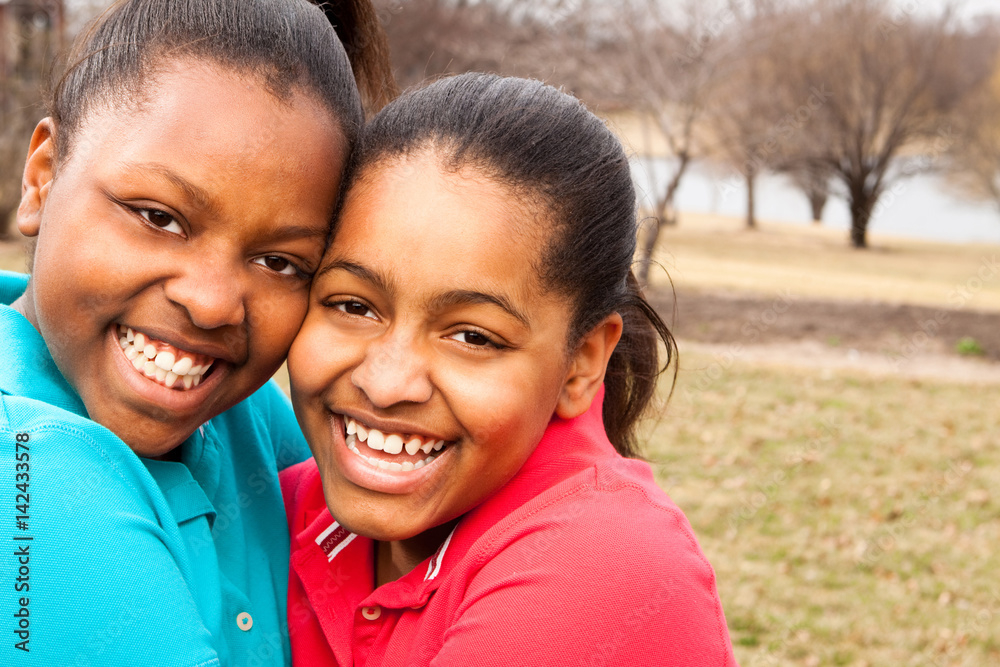 African American sisters and best friends laughing.