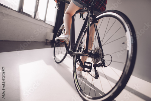 partial view of stylish woman riding sports bicycle