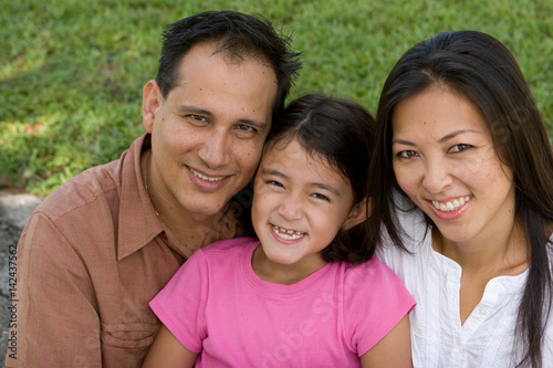 Fotografie Loving Asain parents and their daughters smiling.