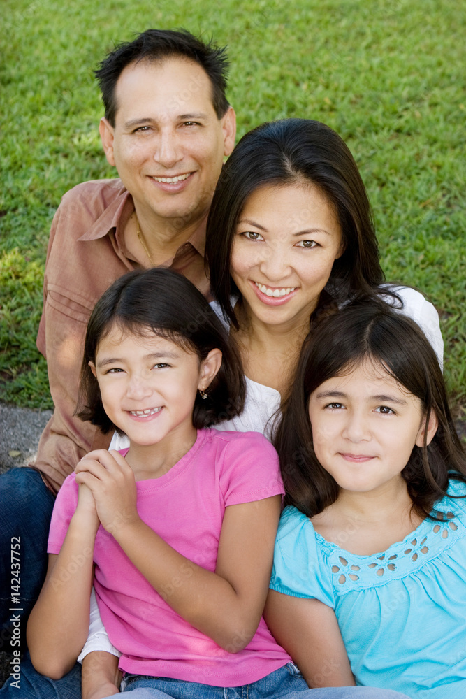 Loving Asain parents and their daughters smiling. Loving Asain parents and their daughters smiling.