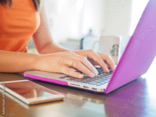 Pretty Young woman using laptop computer. Female working on laptop in a cafe.