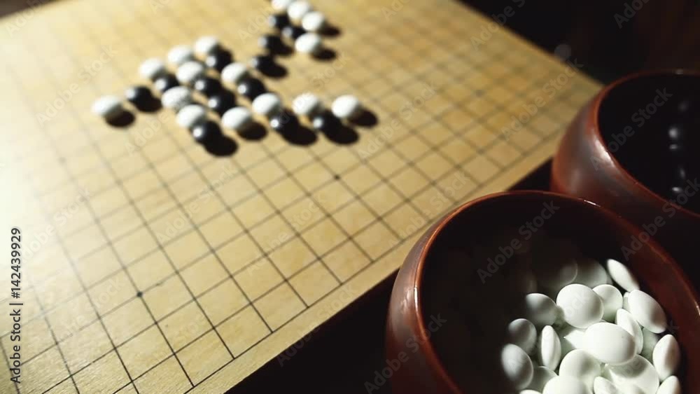 Horizontal panoramic shot of a Go board game, with black and white stones. Horizontal panoramic shot of a Go board game, with black and white stones.
