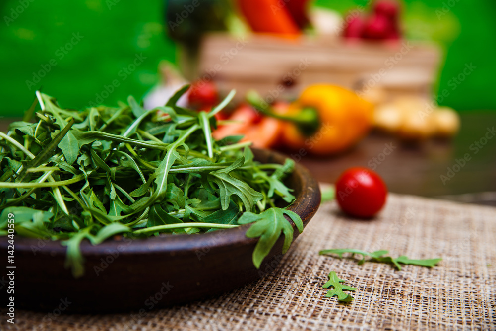 Arugula leaves in bowl. Fresh salad. Natural raw vegetables. Organic bio food on rustic wooden table. Arugula leaves in bowl. Fresh salad. Natural raw vegetables. Organic bio food on rustic wooden table.