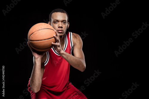 African american basketball player throwing ball on black