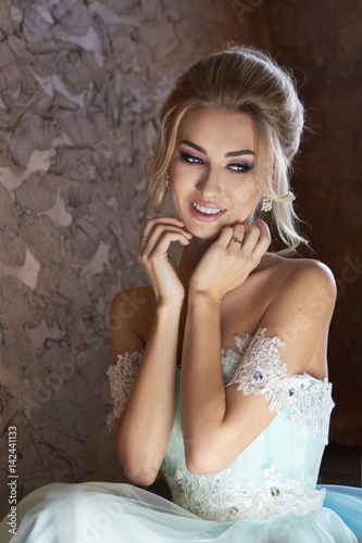 Bride in a beautiful turquoise dress in anticipation of the wedding. Blonde in lace dress sea green. Happy bride, the emotion, the joy on his face. Beautiful makeup manicure and hairstyle women © angel_nt